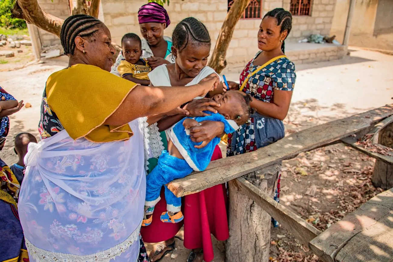 Community health worker providing care to a child in Tanzania